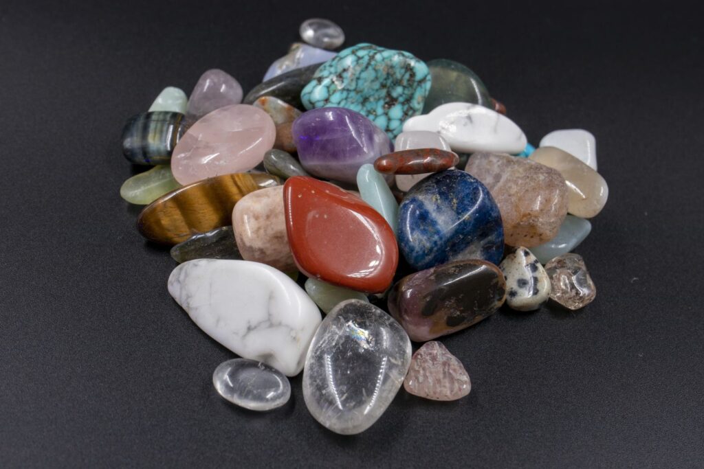 Assorted polished natural gemstones on a dark background