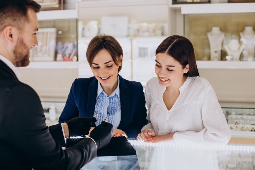 Couple choosing an engagement ring with a jeweller