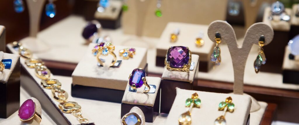 Gold and gemstone rings and earrings in a jewellery showcase