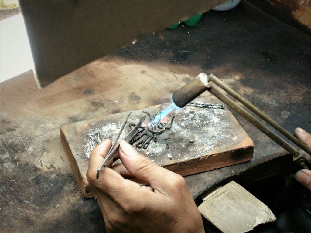 Goldsmith working on gold at a jeweller’s bench