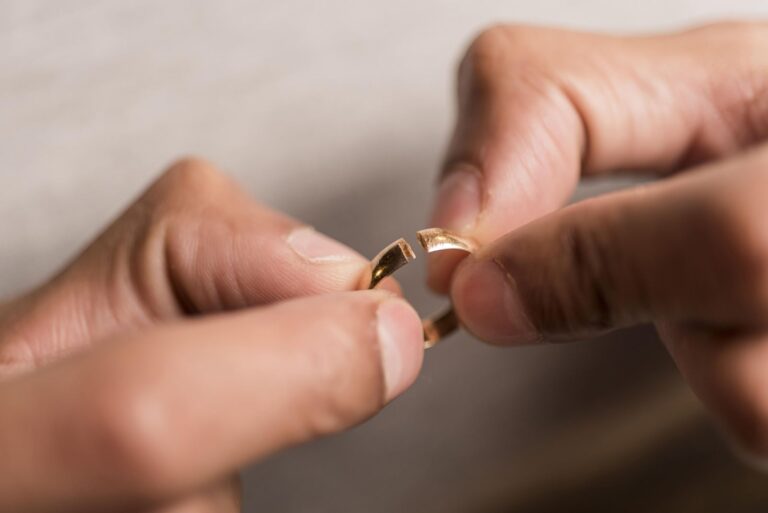 Hands holding a broken gold ring