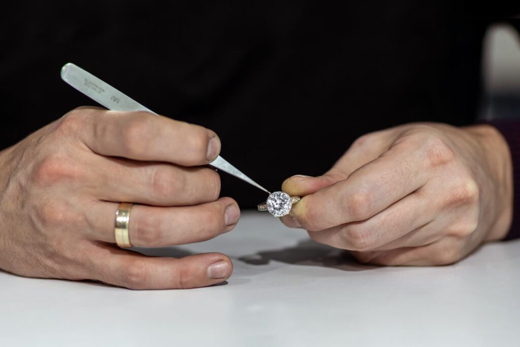 Jeweller checking the stones in a gold ring at the bench