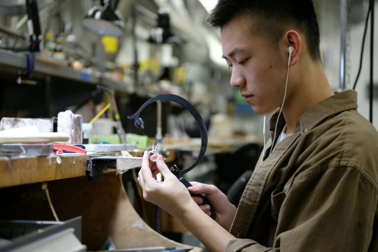 Jeweller using a saw on a ring at the bench