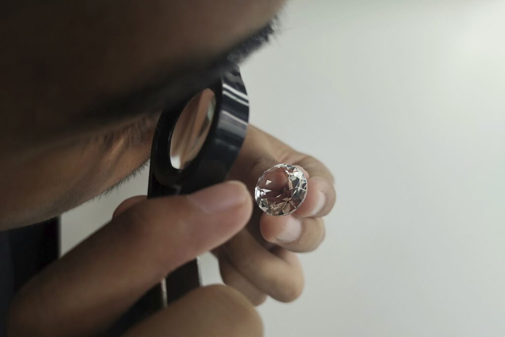 Jeweller examining a polished diamond through a loupe