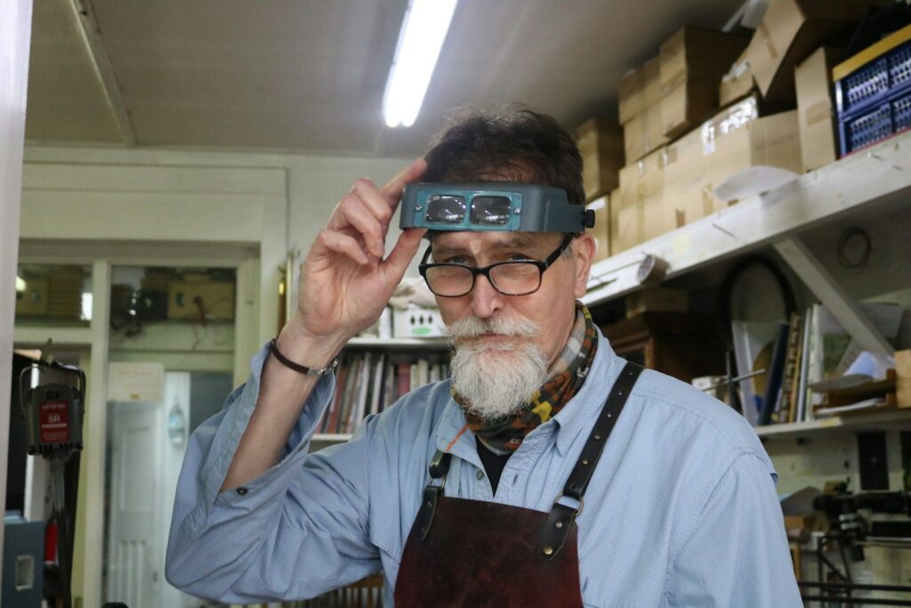 Jeweller with a magnifying visor in the workshop