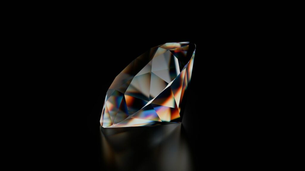 A loose diamond on a dark reflective surface