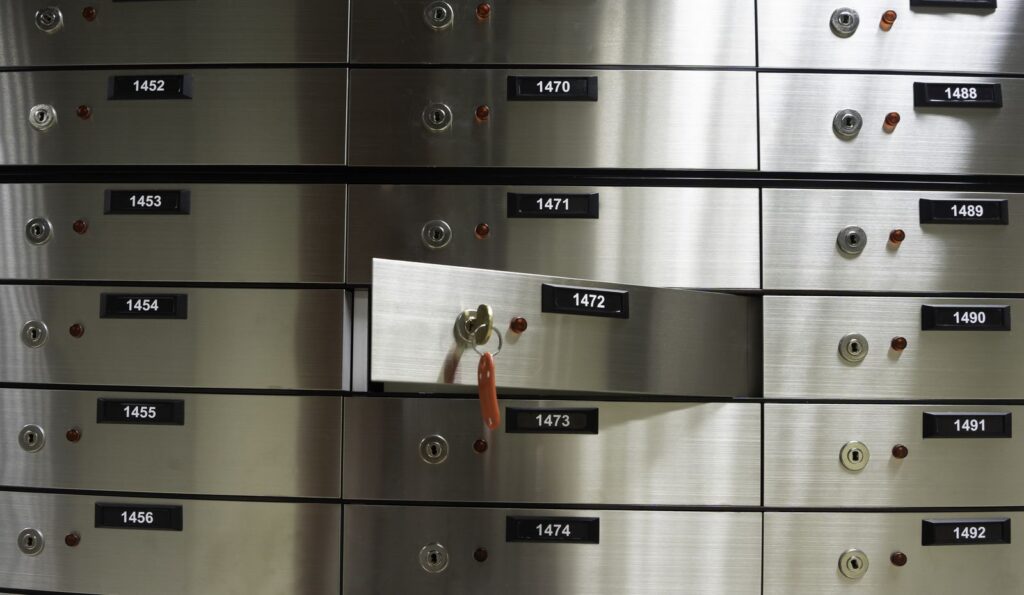 Open safe deposit box with a key inside a bank vault