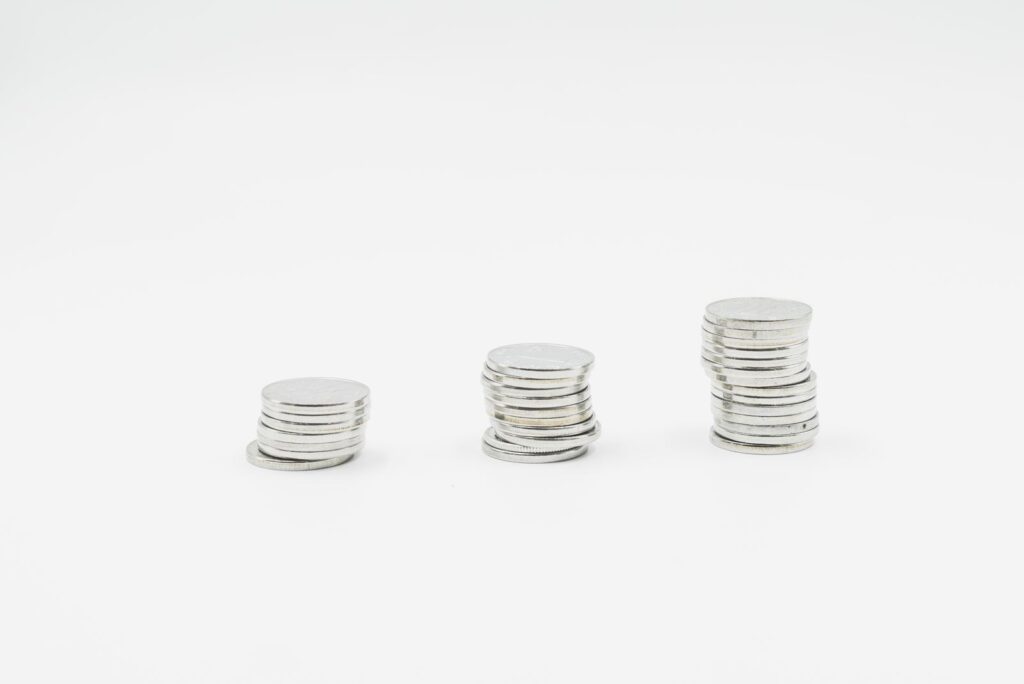Three small stacks of silver coins on a white background