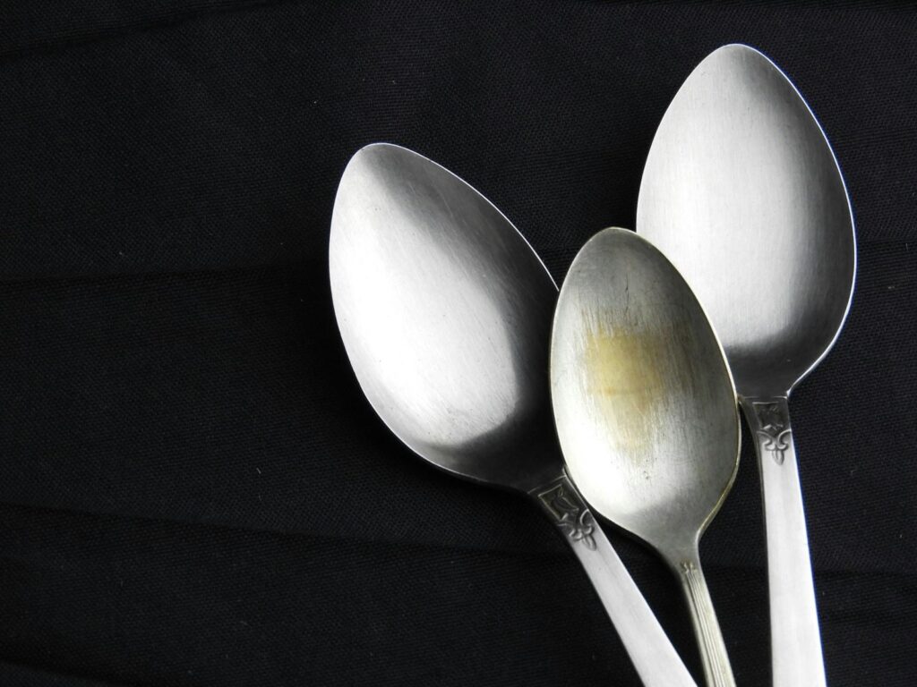 Three silver spoons on black