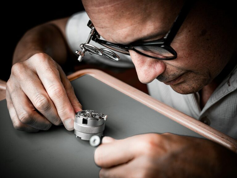 Watchmaker wearing a loupe repairing a watch